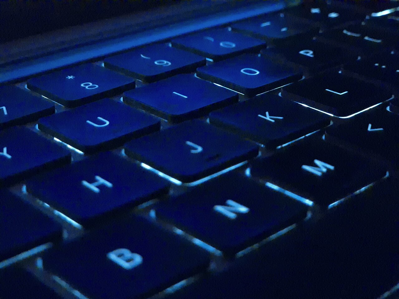 背光 MacBook 键盘特写，用于 AI 桌面助手话题配图