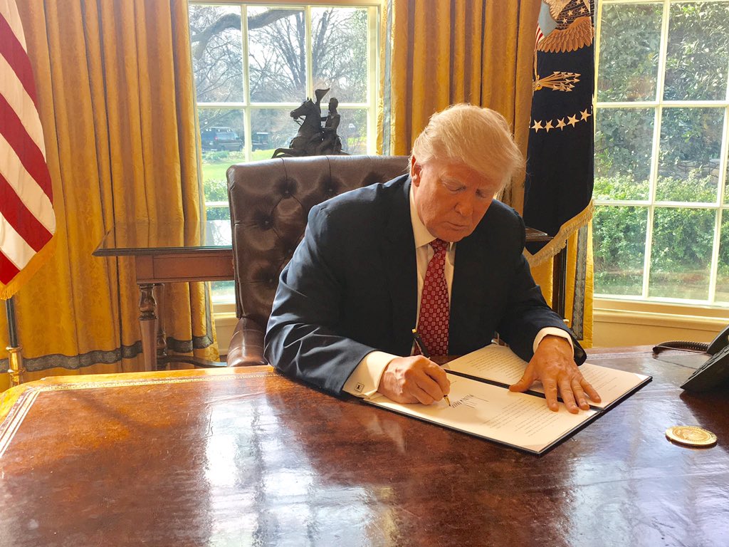 Trump signing an executive order at the White House
